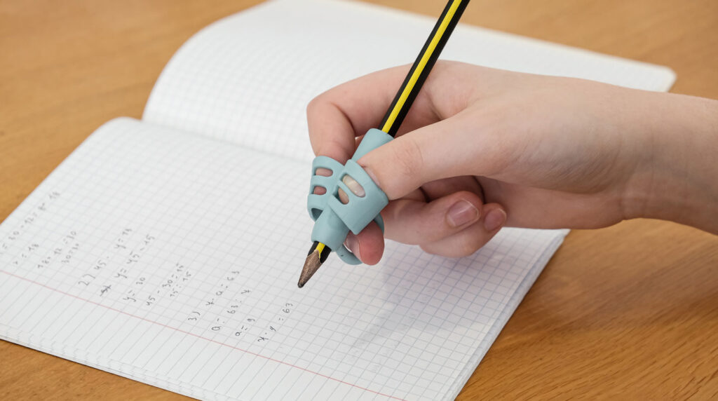 Gros plan sur des mains ridées de personne âgée tenant un stylo et écrivant sur un document, avec un arrière-plan flouté